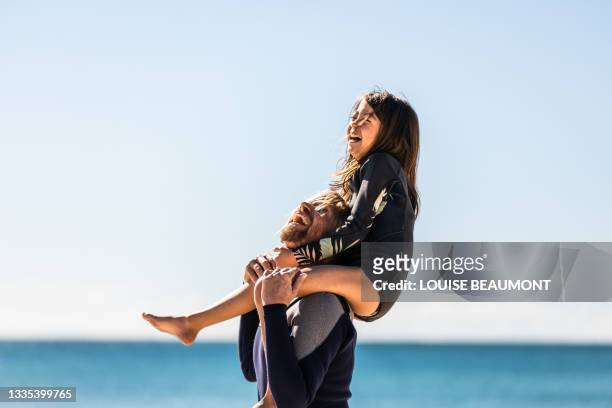 aussie dad gives his daughter a shoulder ride - beach relax stock pictures, royalty-free photos & images