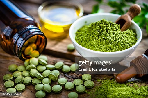 Moringa oleifera powder and pills on rustic table Moringa oleifera powder and pills on rustic table