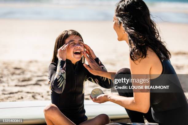 aussie mums helps her daughter apply natural sunscreen - 防曬油 個照片及圖片檔