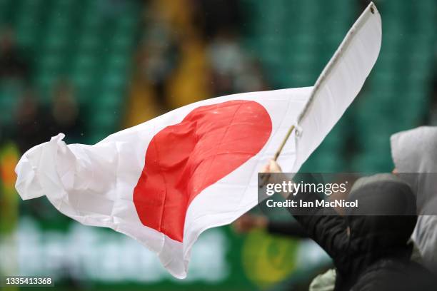 Fan of Celtic waves a flag of Japan prior to the Cinch Scottish Premiership match between Celtic FC and St. Mirren FC at Celtic Park on August 21,...