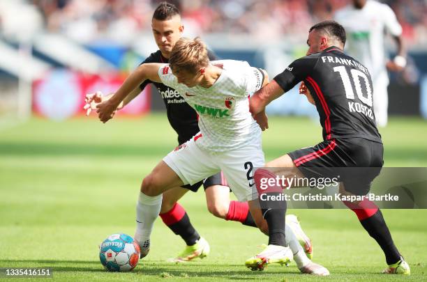 Robert Gumny of Augsburg is challenged by Filip Kostic of Eintracht Frankfurt during the Bundesliga match between Eintracht Frankfurt and FC Augsburg...