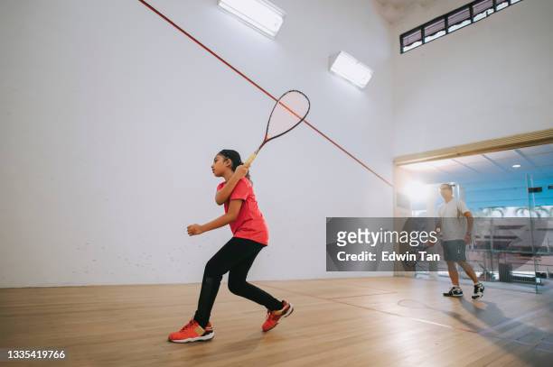 joven jugadora de squash de la india asiática practicando con la guía de su entrenador - squash racquet fotografías e imágenes de stock