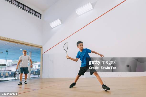 junger asiatischer malaiischer squashspieler übt unter anleitung seines trainers - squash sport stock-fotos und bilder