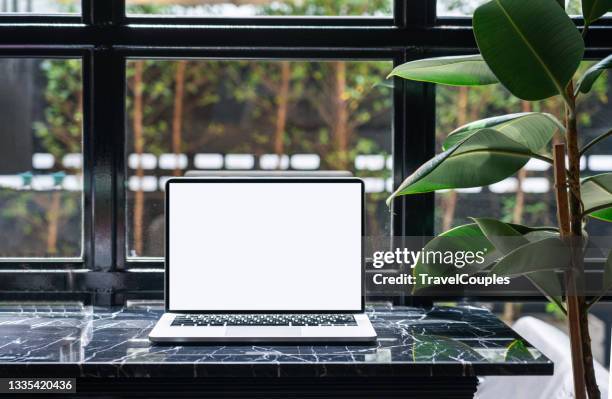 laptop computer blank white screen on table in cafe background. laptop with blank screen on table of coffee shop blur background. - ウェブページ ストックフォトと画像