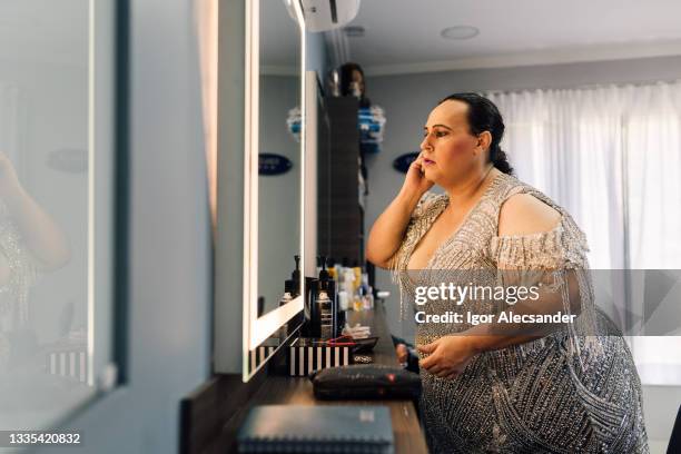 drag queen touching up makeup in the mirror - makeup before and after bildbanksfoton och bilder