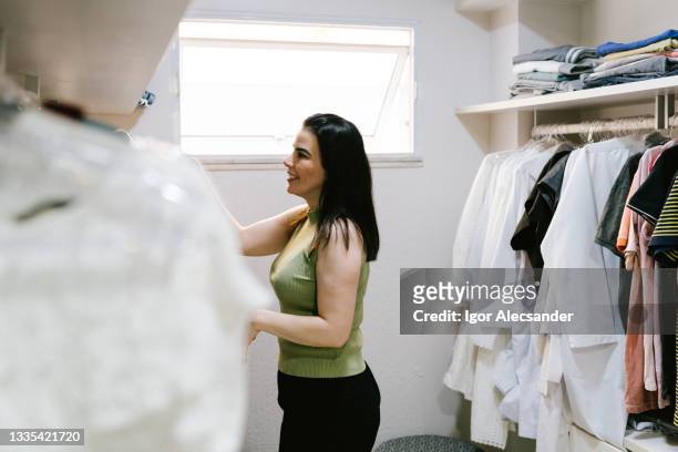 mujer eligiendo ropa en armario - placard fotografías e imágenes de stock