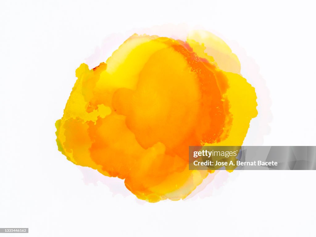 Splashes of a drop of yellow paint on a white canvas.