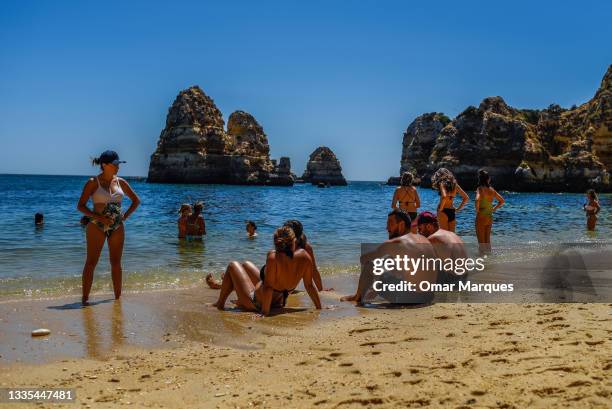 People enjoy the sun in the beach as a heatwave passes by the south of the country on August 17, 2021 in Lagos, Portugal. Portugal has now fully...