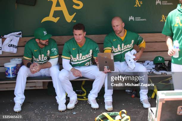 Mitch Moreland, Matt Chapman and James Kaprielian of the Oakland Athletics in the dugout during the game against the Texas Rangers at RingCentral...