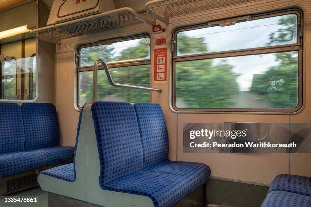 interior view of a corridor inside passenger trains with blue fabric seats of german railway train system. empty vacant passenger car inside the tram. - passenger train stock pictures, royalty-free photos & images