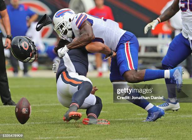 Justin Fields of the Chicago Bears is hit by Andre Smith of the Buffalo Bills during a preseason game at Soldier Field on August 21, 2021 in Chicago,...