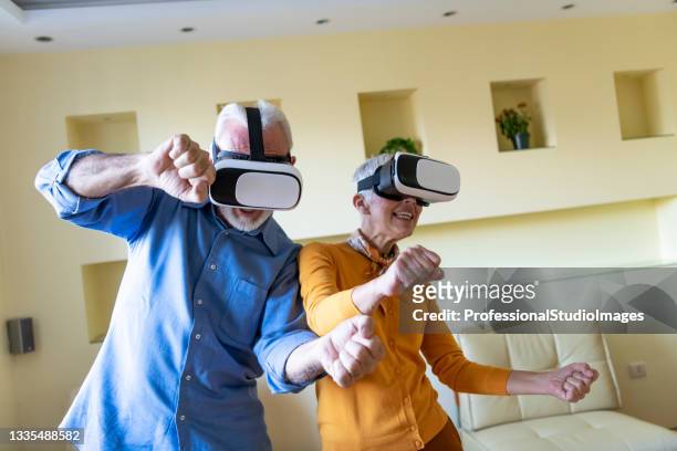 a senior couple is playing games with vr set and facing a different kind of reality. - crazy old lady stock pictures, royalty-free photos & images