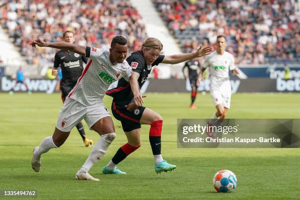 Jens Petter Hauge of Eintracht Frankfurt battles for the ball with Felix Uduokhai of FC Augsburg during the Bundesliga match between Eintracht...