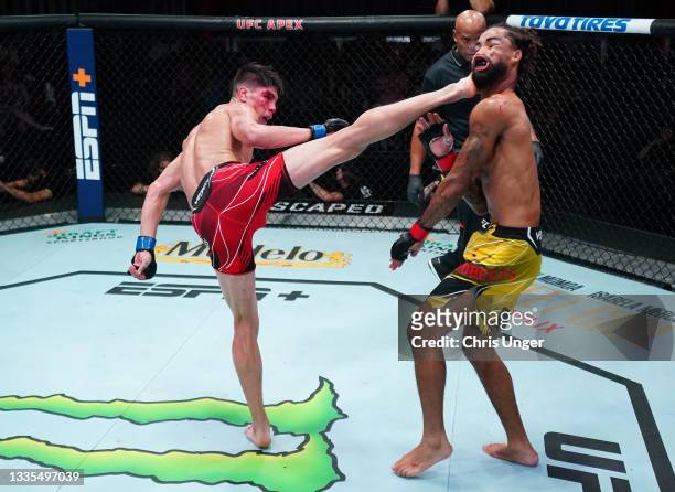 Ignacio Bahamondes of Chile knocks out Roosevelt Roberts with a kick in a lightweight fight during the UFC Fight Night event at UFC APEX on August...