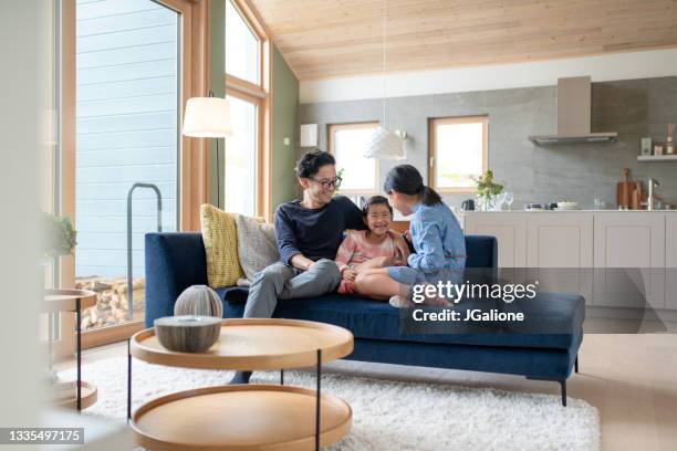 father relaxing with his daughters on the sofa - japansk kultur bildbanksfoton och bilder