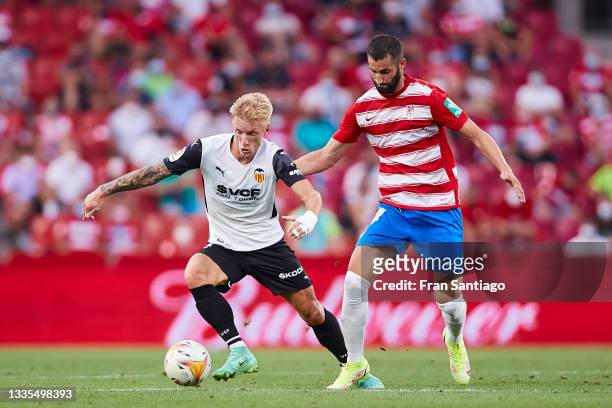 Maxime Gonalons of Granada CF competes for the ball with Daniel Wass of Valencia CF during the La Liga Santander match between Granada CF and...