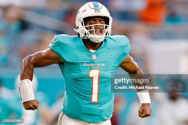 Tua Tagovailoa of the Miami Dolphins reacts to a touchdown run by Myles Gaskin against the Atlanta Falcons during a preseason game at Hard Rock...