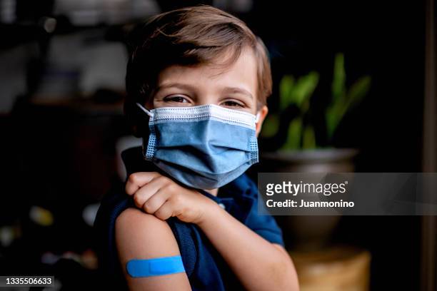 six years old child showing his band aid just after being vaccinated - 5 years stockfoto's en -beelden