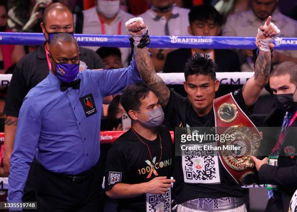 Referee Kenny Bayless holds up the arm of Mark Magsayo after he knocked out Julio Ceja in the 10th round of their featherweight bout at T-Mobile...