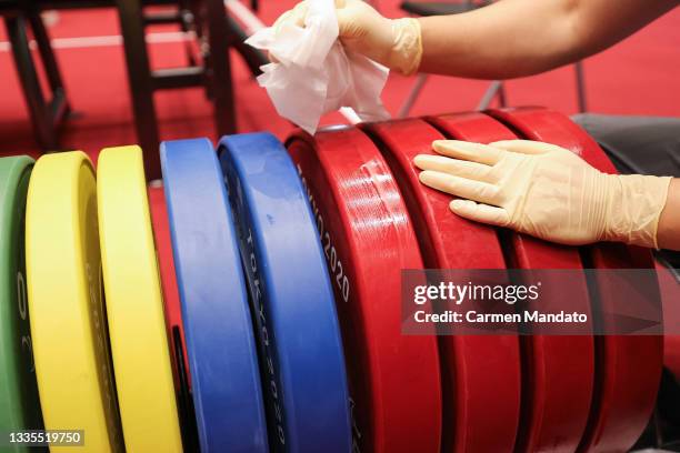 Volunteers clean weights in-between sessions ahead of the Tokyo 2020 Paralympic Games at Tokyo International Forum on August 22, 2021 in Tokyo, Japan.