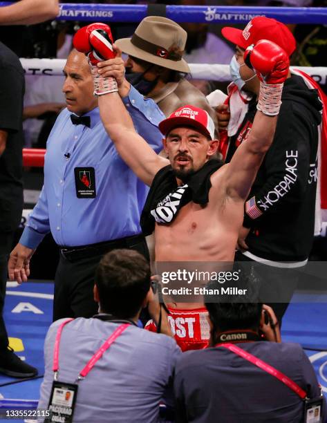 Referee Mike Ortega holds up the arm of Robert Guerrero as he celebrates his unanimous-decision victory over Victor Ortiz in their welterweight bout...