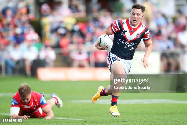 Lachlan Lam of the Roosters breaks away from the tackle of Jack De Belin of the Dragons during the round 23 NRL match between the St George Illawarra...