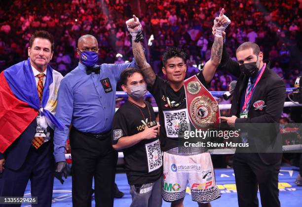 Mark Magsayo poses with referee Kenny Bayless and members of his team after knocking out Julio Ceja in the 10th round of a featherweight bout at...