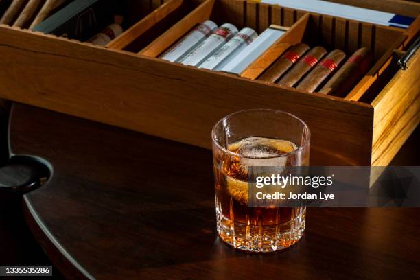 a glass of whisky and cigars in lounge - cognac glass stock-fotos und bilder