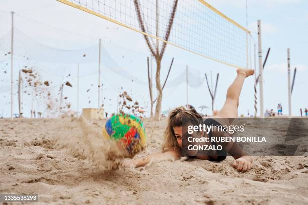 female playing beach volleyball diving to catch ball - girls beach volleyball stock pictures, royalty-free photos & images