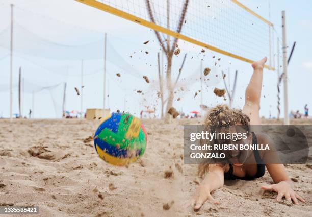 female playing beach volleyball diving to catch ball - beach volleyball stock pictures, royalty-free photos & images