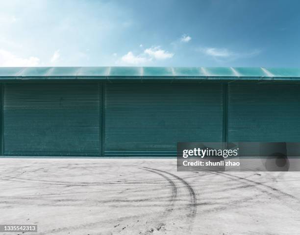 cement floor against green wall - parking garage stock-fotos und bilder