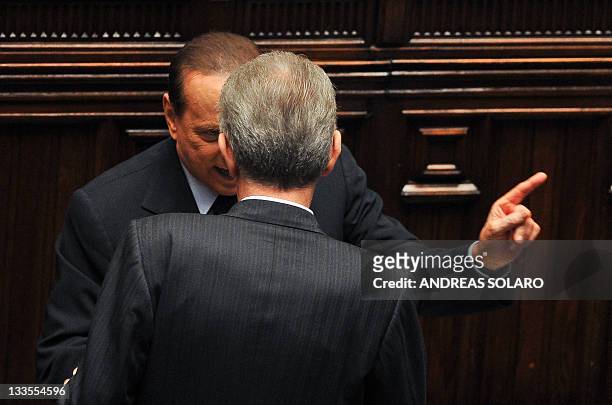 Italy's former Prime minister and head of the Popola della liberta party's group at the lower-house, Silvio Berlusconi speaks to Prime Minister Mario...