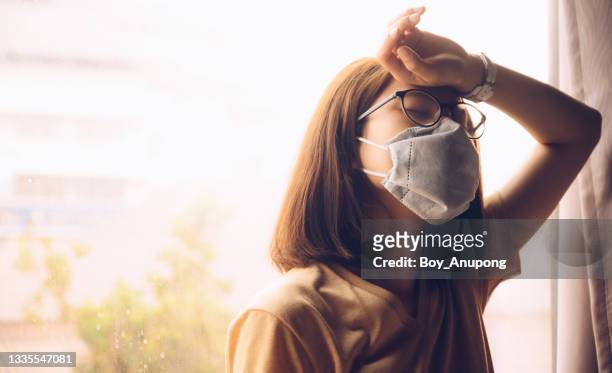 asian woman having headache and tired while wearing mask for protect virus disease in covid-19 pandemic outbreak. - hot boy body stock pictures, royalty-free photos & images