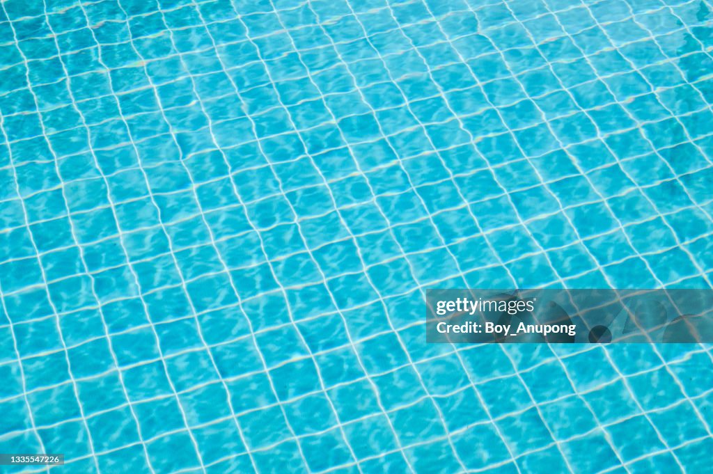 Abstract view of bottom caustics of swimming pool with ripple and flow on water surface.