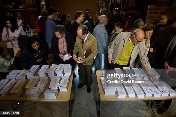 Voters take their ballot papers before casting them for Spain's General Elections on November 20, 2011 in Barcelona, Spain. Spaniards are going to...