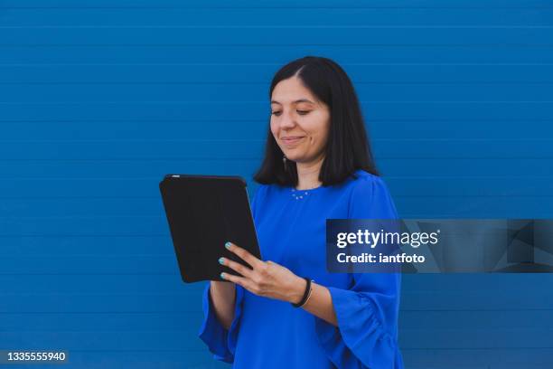 young beautiful woman with blue shirt working with a digital tablet. - graphics tablet stock pictures, royalty-free photos & images