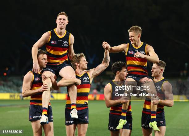 Tom Lynch of the Crows and David Mackay of the Crows are chaired off the ground during the round 23 AFL match between Adelaide Crows and North...