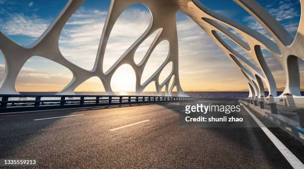 bridge over the sea at sunrise - dramatic sky perspective stock pictures, royalty-free photos & images