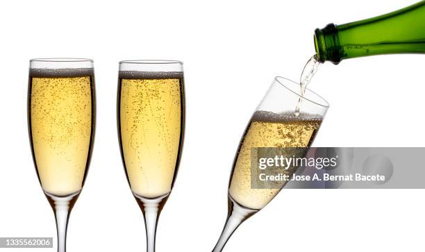 fill champagne glasses with the bottle on a white background. - glass half full party stock pictures, royalty-free photos & images