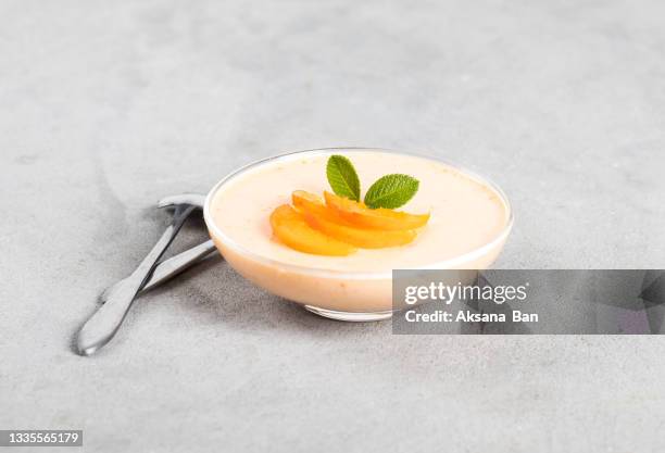 jelly apricot in a glass cup on a light gray background - gelatin dessert stockfoto's en -beelden