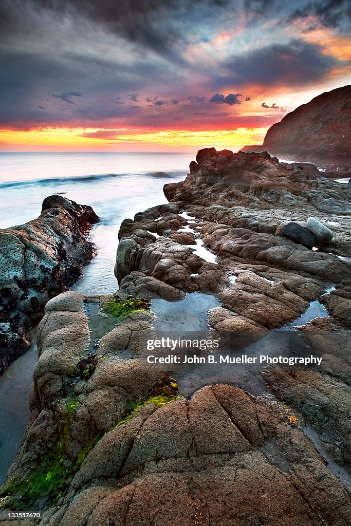 Tide pools in pacific ocean at sunset