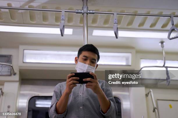 people wear protective face mask during stay on commercial train. - taken on mobile device stock pictures, royalty-free photos & images