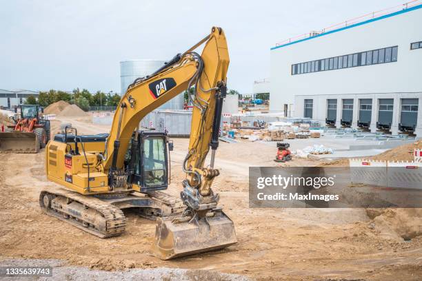 baustelle mit baumaschinen, baggern, bulldozern und lkws - rebuilding stock-fotos und bilder