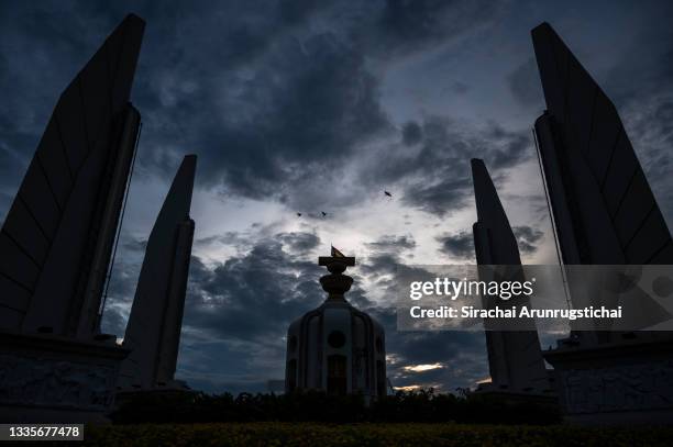 Bird are seen flying over the Democracy Monument at sundown on August 22, 2021 in Bangkok, Thailand. Anti-government protesters have continued to...