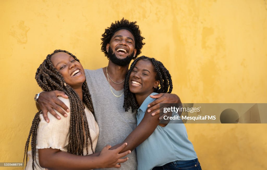 Hugging afro people yellow background