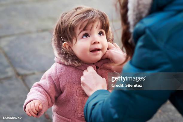 a mother is buttoning her daughter's coat - casaco - fotografias e filmes do acervo