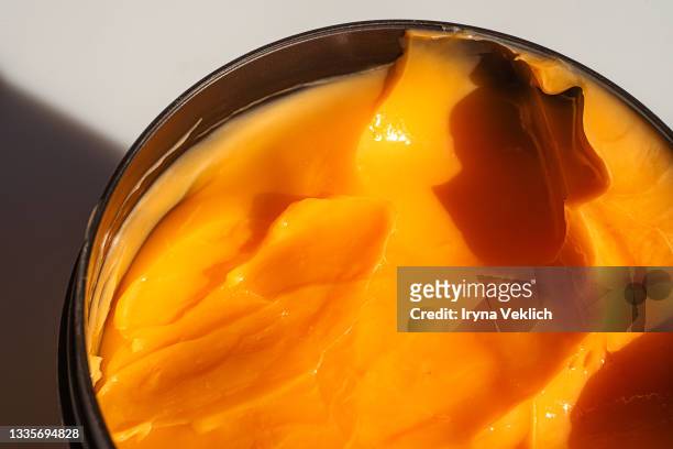 gloss texture of orange color beauty product facial body cream or hair mask. - hair conditioner stockfoto's en -beelden