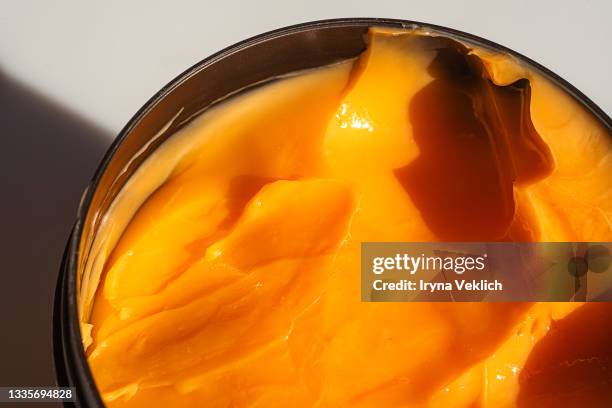 gloss texture of orange color beauty product facial body cream or hair mask. - hair mask stock pictures, royalty-free photos & images