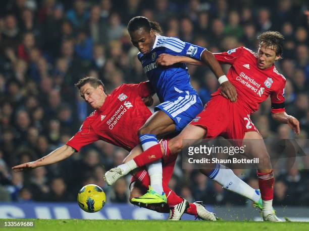 Didier Drogba of Chelsea is tackled by Lucas and Daniel Agger of Liverpool during the Barclays Premier League match between Chelsea and Liverpool at...