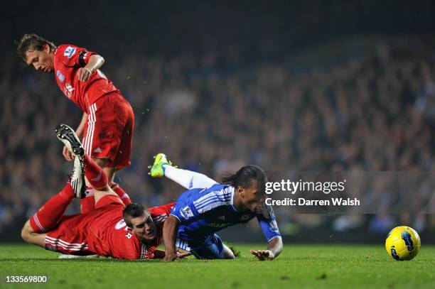 Didier Drogba of Chelsea is tackled by Daniel Agger of Liverpool during the Barclays Premier League match between Chelsea and Liverpool at Stamford...